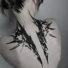 Abstraktes Blackwork-Rücken-Tattoo im OMEN Tattoo Studio Berlin. Ausdrucksstarke, dunkle Linien mit scharfen Kanten und dynamischer Wirkung.