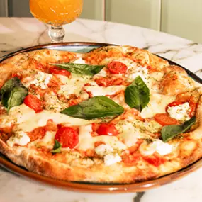 Mauritius Pizza, unsere knusprig-luftige Pizza besteht aus einem Sauerteig, der aus Weizen-, Reis-, Mais- und Sojamehl hergestellt wird und 72 Stunden ruht. Jede Pizza wird bei uns mit Fior die Latte Mozzarella zubereitet, mit Liebe belegt und mit Olivenöl Extra Vergine verfeinert.