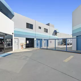 Secure gated access point at Spencer Street Self Storage featuring blue security gate, controlled entry system, and clear facility access.