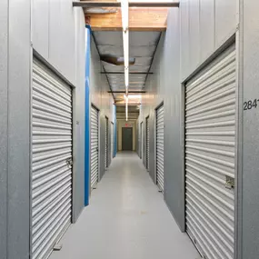 Spencer Street Self Storage interior hallway featuring clean, well-lit corridors and secure individual storage units. Each unit is clearly numbered and accessible via roll-up doors in our professionally maintained indoor storage section.