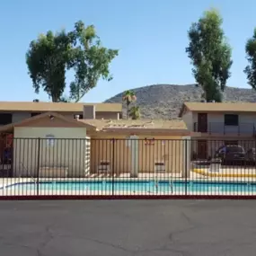 A pool in front of a house with a mountain in the background.