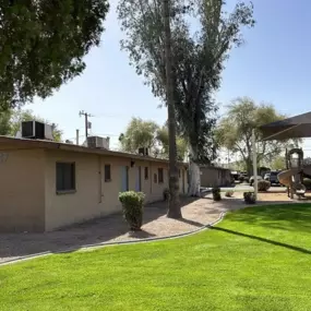 A row of houses with a green lawn in front.