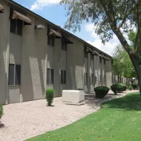 A long building with a lot of windows and bushes in front.