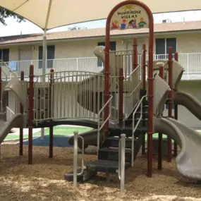 A playground with a slide and a climbing frame.