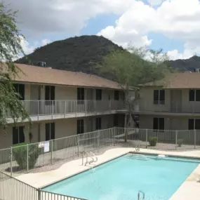 A pool surrounded by a fence in a courtyard.