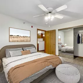 a bedroom with a bed and a ceiling fan