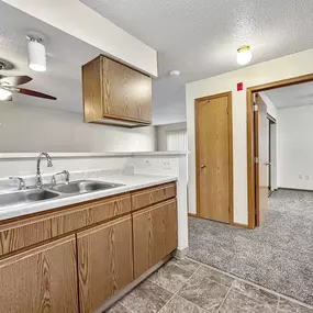 a kitchen with a sink and a ceiling fan