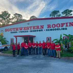 Partial men’s team in Houston gathered outside with trucks and full company service board.