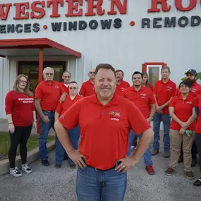 Company leader stands proudly outside our Houston roofing headquarters with part of our skilled crew.