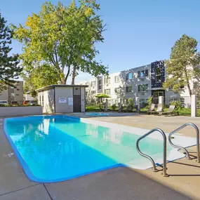 A swimming pool with an apartment building in the background