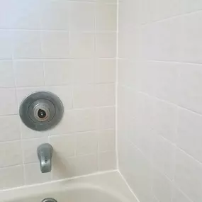 This image displays a bright, clean bathtub and tile wall meticulously restored by The Groutsmith. Pristine grout lines and refreshed tiles demonstrate expert cleaning, sealing, and detailing for a like-new appearance.