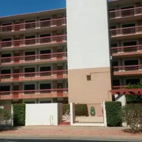 A large red brick building with balconies and a white door in front.