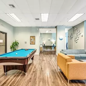 A game room with a pool table and couches