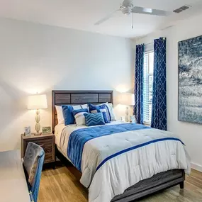 A bedroom with a bed and a ceiling fan