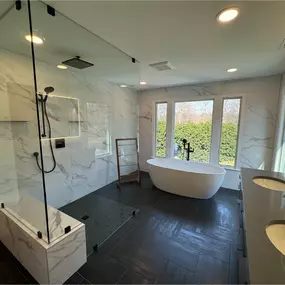 Reston Primary Bathroom Refresh - A bathroom refresh for a client that plans to sell their house in a few years but wants to enjoy a new updated space now. The layout has some small but important tweaks. We changed the bathroom door location and made it a pocket door to allow for a deeper shower with a wide niche. The shower faucet handle is near the door so you can turn on the water before you get into the shower. This is a curbless shower for a more modern look. We reconfigured the walls aroun