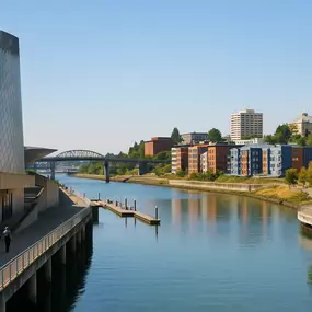 Daytime waterfront view in Tacoma, WA featuring the Museum of Glass, Foss Waterway, and modern downtown buildings.