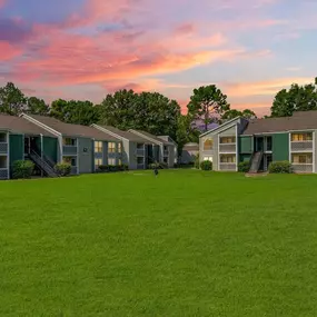 A row of houses with green lawns in front
