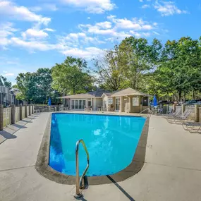 A swimming pool surrounded by a fence and trees