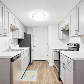 A kitchen with white cabinets and a white counter top.