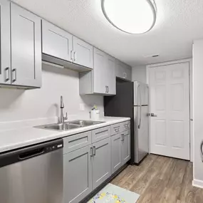 A kitchen with a white counter top and stainless steel appliances