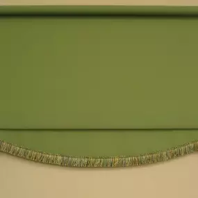 Light green roller shade with a curved multicolored bottom edge