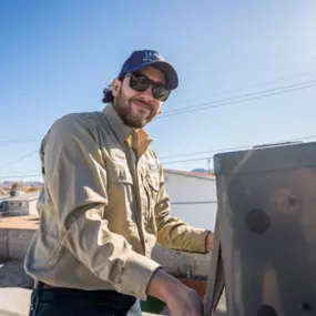 A technician labeled “Riley” works on rooftop ac equipment, smiling and looking at the camera.