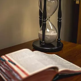 A still moment of inspiration—an open Bible beside an hourglass.