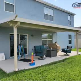 House with customized patio cover surrounded by grass landscape