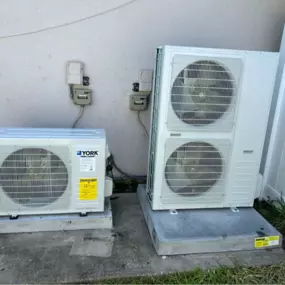 Dual York heat pumps installed side-by-side on hurricane-rated pads in St. Cloud, FL. Built for high-efficiency performance with clean mounting, drainage, and electrical connections.