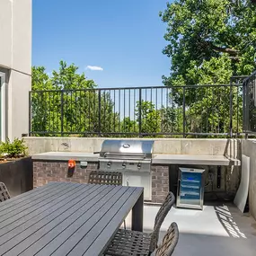 A patio with a table and chairs overlooking a tree