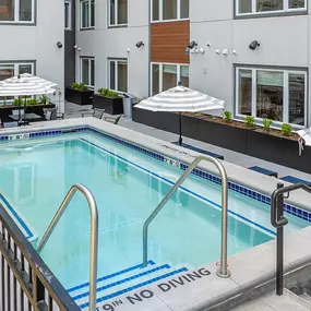 A pool with a diving board and a sign that says