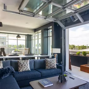 A modern living room with a dark blue sofa and a glass ceiling