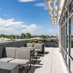 A rooftop patio with a table and chairs