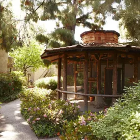 a bird aviary in a garden with plants and trees