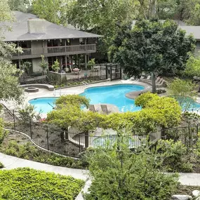 an aerial view of the backyard of a house with a swimming pool