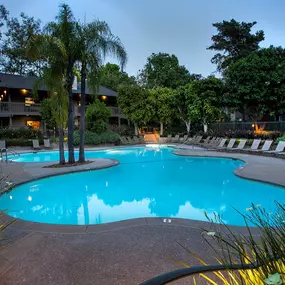 a swimming pool at night at an apartment community