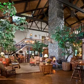 the lobby of a clubhouse with a large living room and a staircase