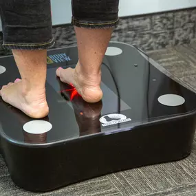 A patient standing on a foot leveler's scanner