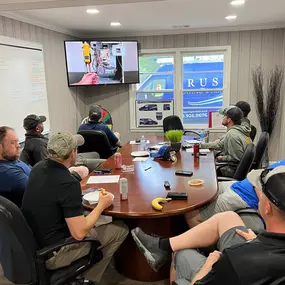 A professional team gathers for a meeting around a table, actively engaged in discussion and collaboration. Team members review documents, share ideas, and plan next steps, reflecting strong communication, teamwork, and strategic planning. This image highlights company culture, internal leadership, and the importance of coordinated effort in delivering high-quality service—perfect for businesses focused on customer care, service excellence, or project management.