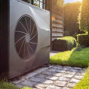 A residential outdoor air conditioning unit sits on a concrete pad beside a home, designed to provide reliable cooling during hot weather. The condenser is clean and professionally installed, with visible coils, fan, and protective casing. This image represents efficient home cooling, proper HVAC installation, and the importance of regular maintenance to extend system life and ensure energy-efficient performance. Perfect for promoting A/C service, repair, or system replacement.