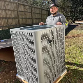 HVAC technician Josh stands proudly next to a newly installed air conditioning unit outside a residential home. The brand-new A/C system is professionally placed on a level pad, ready to deliver efficient cooling and improved indoor comfort. Josh is representing At Techmazing Heating & Cooling’s commitment to expert service, quality installations, and customer satisfaction. This image highlights successful A/C replacement, reliable technicians, and energy-efficient home upgrades.