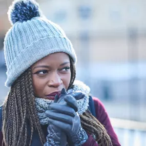A woman dressed in a winter hat, heavy jacket, and scarf is visibly cold indoors, suggesting her home’s heating system may not be working properly. Her layered clothing and uncomfortable expression highlight the need for reliable furnace repair, emergency HVAC service, or seasonal heating maintenance. This image is perfect for promoting residential heating services, energy-efficient upgrades, and winter readiness for homeowners facing chilly indoor temperatures.