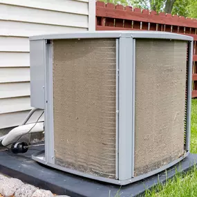 A close-up of a very dirty and dust-covered air conditioning unit shows clogged fins, debris buildup, and visible signs of neglect. The grime reduces airflow and cooling efficiency, signaling the urgent need for professional HVAC cleaning, routine maintenance, or potential system repair. This image highlights the importance of seasonal A/C service, proper filter replacement, and regular upkeep to avoid costly breakdowns and ensure reliable home cooling.