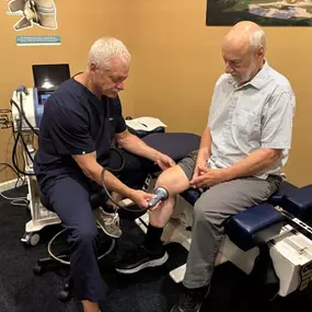 Dr. R. Todd Kirstein performing shockwave therapy on a patient's knee