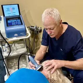 Dr. R. Todd Kirstein performing shockwave therapy on a patient's neck
