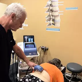 Dr. R. Todd Kirstein performing shockwave therapy on a patient's back