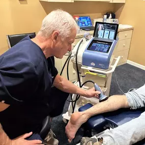 Dr. R. Todd Kirstein performing shockwave therapy on a patient's calf