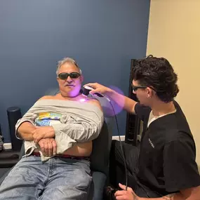 Nelson Ocasio giving a patient laser therapy