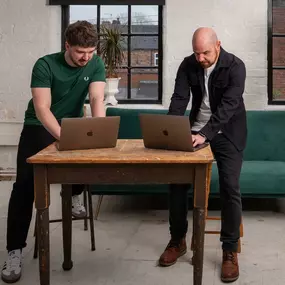 A photograph of Ian Hazeldine and Callum Williams coding and designing a website