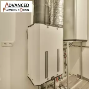 A modern tankless water heater system is professionally installed by Advanced Plumbing & Drain, featuring clean piping and ductwork in a utility room.